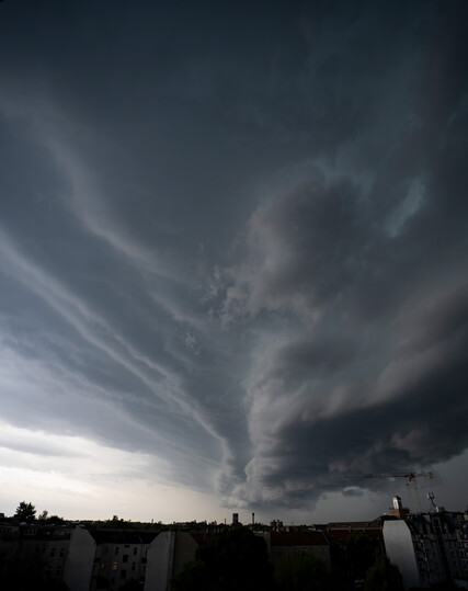 A massive dark cloud bank rolling in, dragging a large rainstorm along with it.