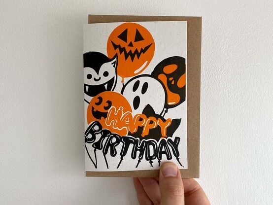 A spooky birthday card featuring monster and pumpkin balloons with the words 'Happy Birthday' spelt out in tube balloons. 