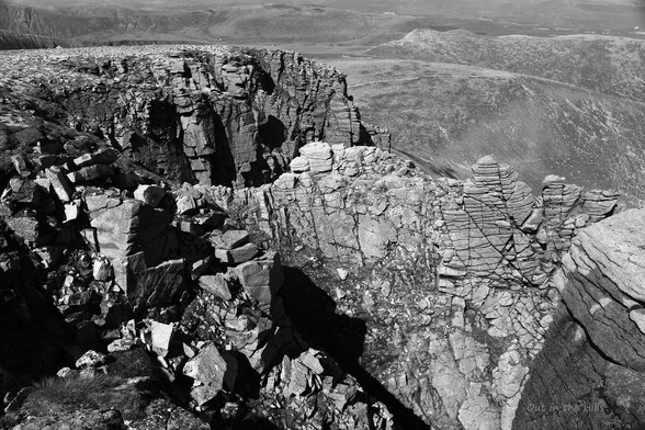 Black and white. Looking down onto granite crags.