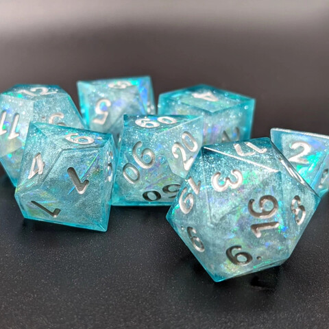 Polyhedral tabletop RPG dice. Inserts made from pearl white mica powder and iridescent cellophane, shelled in aquamarine resin dye. Numbers painted silver.