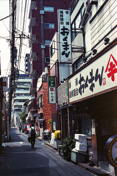 A man seen in an alley walking home after a long week; with Fujifilm Reala 100 and Leica M6