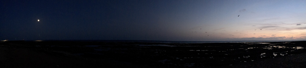 On the left the night is coming and we can see the full moon and on the right we can see the last colors of the sunset
