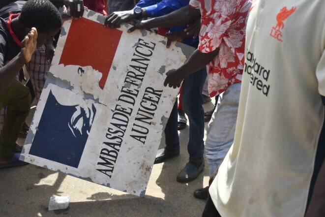 Des manifestants tiennent une pancarte prise à l’ambassade de France à Niamey lors d’une manifestation de soutien à la junte nigérienne à Niamey le 30 juillet 2023. © AFP