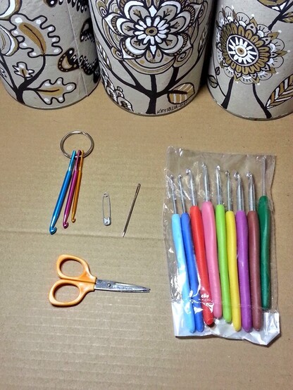 Une partie des garnitures, c'est un exemplaire à chaque fois de ce que contenait chaque boîte pour le cadeau :

Un porte-clé crochet, une aiguille à une épingle à nourrice, un lot de crochet de différentes tailles, un petit ciseaux vintage en celluloïde, et il y avait également trois pelotes assorties dans chaque boîte pour expérimenter. 

Ce cadeau faisait suite au fait que j'avais appris aux personnes à qui elles étaient destinées à crocheter pendant une après-midi, il s'agissait de leur offrir le matériel pour mettre en pratique ce qu'elle avait appris mais comme je le disais je doute que ça ait été ouvert ne serait-ce qu'une seule fois. 