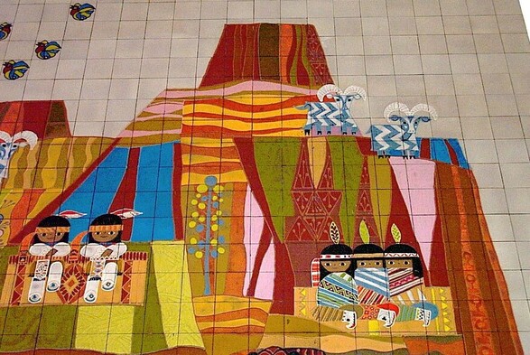 Blair, Mary (1971), "Mosaic", Contemporary Resort, Disney. CC BY-SA 3.0 
Featuring five illustrated native-american people with feathers and the heads, head bans, and colorful and patterned clothes. There are two on the left and three on the right covered with ponchos. There is a mountain behind and three blue rams. Four visible birds in the sky. 
 Illustration on tiles.
Wikipedia.