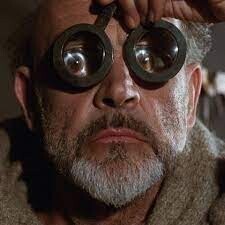 Screenshot from The Name of the Rose. The Franciscan friar William of Baskerville is using a pair of eyeglasses in the scene. 