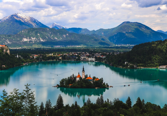 Photo of Lake Bled in Slovenia with Bled Island at its center and Alpine mountains in the background
