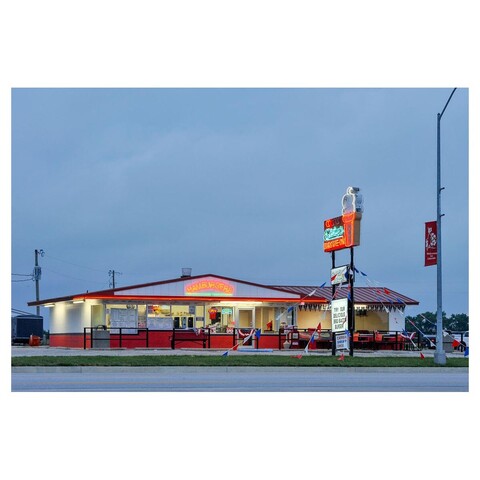 Drive-in restaurant at dusk, neon signs and walk-up windows. Taken from opposite side of street