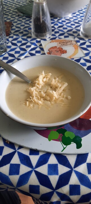 A bowl full of celery soup topped with cheese