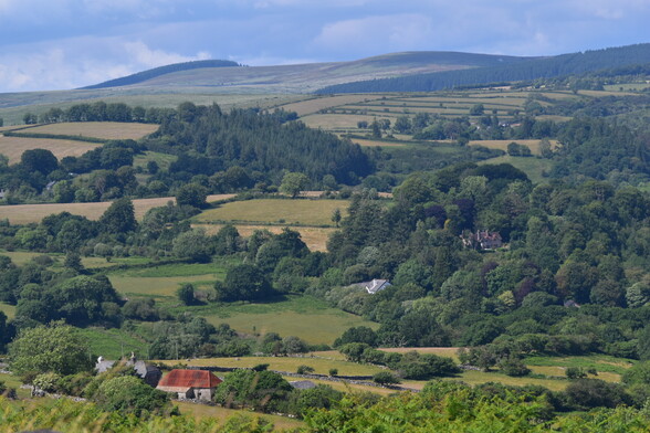 A pastoral view of fields and moorland behind .