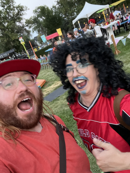 Me on the left, a wide-mouthed excited person in a baseball cap. To the left, the unequaled Queerd Al, a drag performer in a curly black wig and painted blue facial hair in a jersey. It’s a magical meeting full of joy and wonder. 