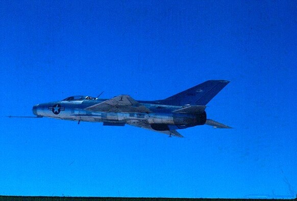 A captured MiG-21 in flight from the left