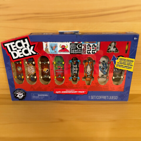 Eine Packung mit acht verschiedenen Fingerboards der Firma TechDeck auf einem Holzregal. 
