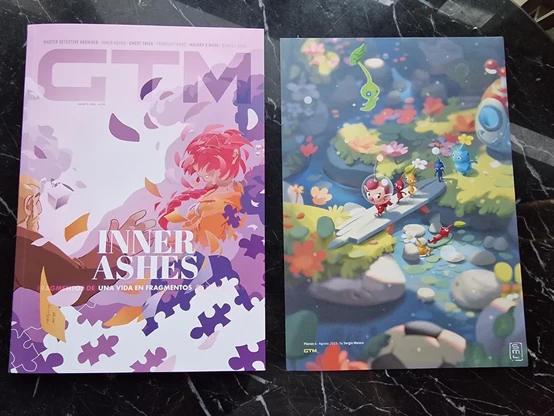 Foto de la revista GTM cuya portada está dedicada al juego Inner Ashes. Junto a la revista hay una lámina ilustrada dedicada a la saga Pikmin