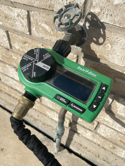 A Rain Bird sprinkler timer with a blacked-out LCD display due to the heat.