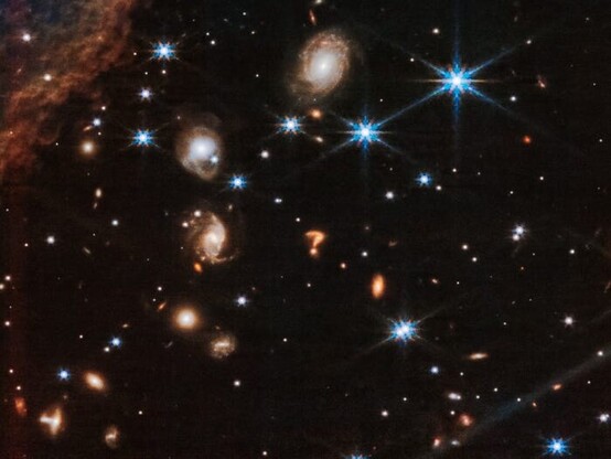 A NASA picture from the JWST space telescope showing two galaxies distorted into the shape of a question mark ❓