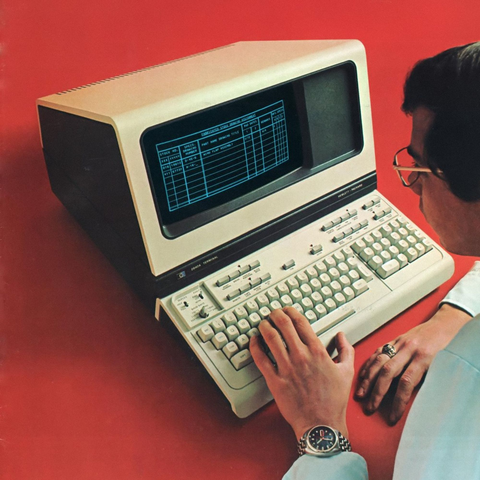 A man using a different all-in-one desktop computer with a monochrome screen.
