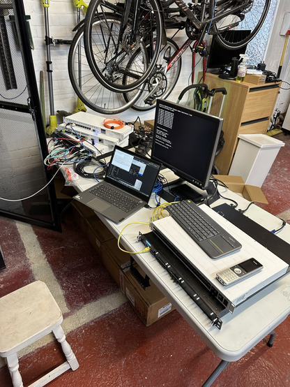 Table with various routers being configured with laptop