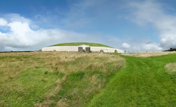 The passage tomb at Newgrange, a megalithic structure with a quartz rock face viewed from the perimeter of the site
