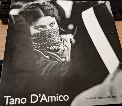 Front cover of a book showing a woman with a mask covering part of her face standing behind a policeman.