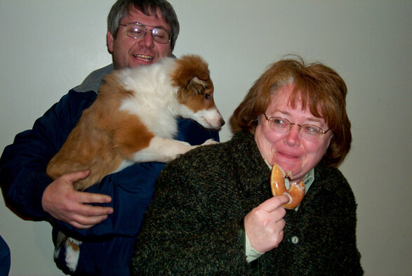 A picture of my wife holding a donut cowering away from a dog. The dog is held by her brother. It is a very funny picture!! 