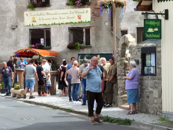 Teilnehmende des "Volksfestes" stehen vor einem Gebäude