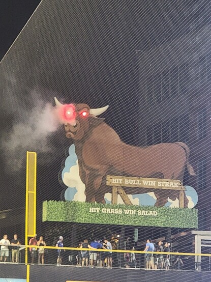The large bull sign behind the left field fence has the smoke from its nose lit up by its glowing red eyes after the Durham Bulls victory over the Gwinnet Stripers on Saturday night.
