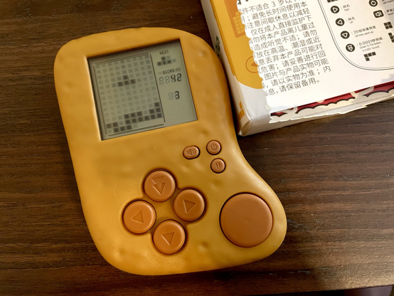 The Tetris chicken nugget with a paused Tetris game on the screen. The instructions are visible in the nugget box