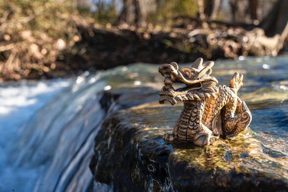 Photo of a river with a small statue of a Chinese dragon sitting in it