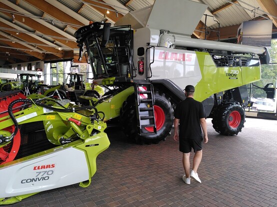 Eine Person vor einem Claas Mähdrescher im Claas Showroom