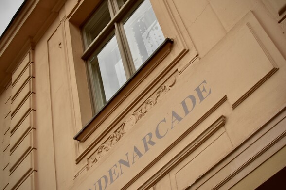 Windowframe in faux stone of beige plaster with name “Lindenarcade”