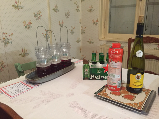 Sur une table molletonné de vielle baraque normande, trois pièges à frelon, un pack entamé de mini-Heineken, un sirop de fraise de marque Frucci, et une bouteille de vin alsacien qui vit ici sa meilleure vie.