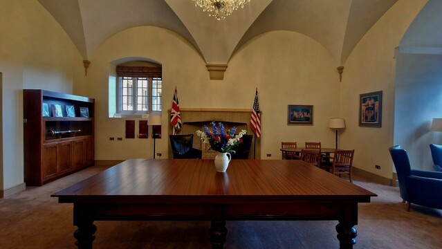 A large table in a room with the US & UK flags in the background