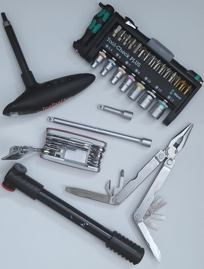 Foto eines Satzes Fahrradwerkzeug für unterwegs
Icetoolz Drehmomentschlüssel
Wera Bit-Sortiment Tool Check Plus
Leatherman Multitool
Mini Luftpumpr
Sigg Multiwerkzeug