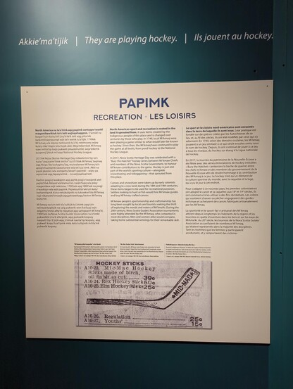 A museum plaque with a picture of an early Mi'kmaw hockey stick design and a bunch of descriptive text