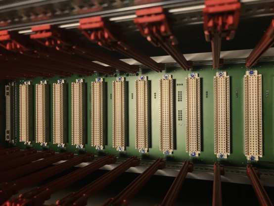 A photo of a VME64 backplane, with red card retainers.