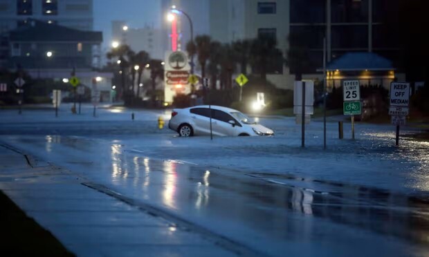 A car driver has driven into a watery median during stormy weather.
From https://www.theguardian.com/us-news/2023/aug/31/hurricane-idalia-florida-north-south-carolina-georgia