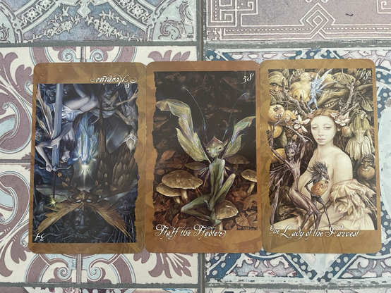 3 faerie’s oracle cards spread on a purple tiled floor. The left card is reversed, the others are upright. 