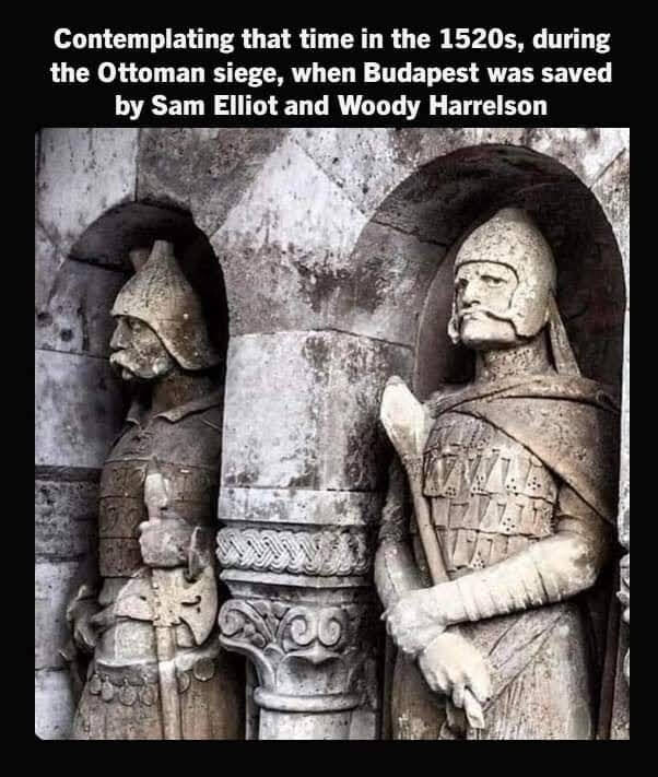 Sculptures of two knights, one who resembles Sam Elliot and the other Woody Harrelson. Text reads: Contemplating that time in the 1520s , during the Ottoman siege, when Budapest was saved by Same Elliot and Woody Harrelson.
