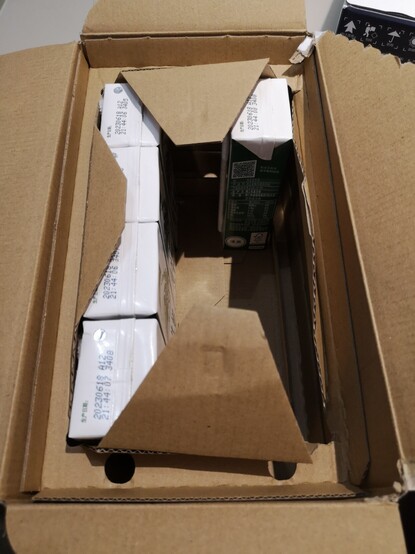 Das zweite Foto zeigt den geöffneten Karton von oben. Die 12 kleinen Milchverpackungen im Inneren wurden mit reichlich Luft eingepackt. Die Milchverpackungen wurden in der Mitte fixiert und außen herum gibt es einen Rand mit jeweils ca. ein bis zwei Zentimetern Luft.