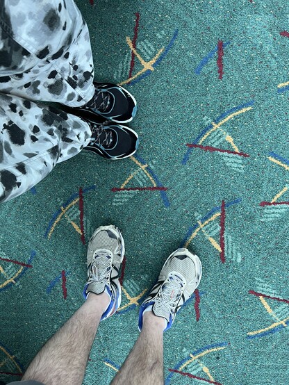 2 pairs of feet standing on the new PDX carpet 