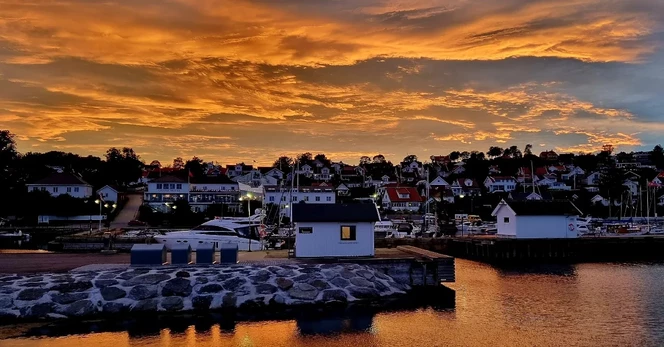 Dark orange sunset clouds reflected over Asgardstrand Harbour 