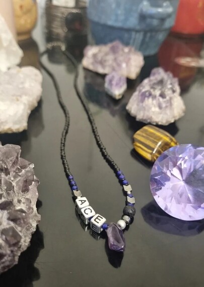 Handmade beaded necklace with silver ACE letters and amethyst gemstone 
Side angle