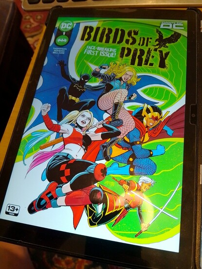My tablet screen showing the cover of 2023s new Birds of Prey #1 featuring Black Canary, BigBarda Batgirl(Cassandra Cain) Zealot & Harley Quin charging toward the camera