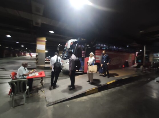 Passengers buying a ticket from a bus counter.