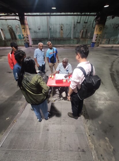 Passengers buying ticket from a bus counter.