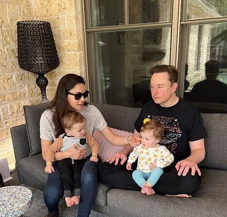 Elon Musk mit der Mutter und deren beiden Zwillingen - er macht dabei einen erstarrten fast abwesenden Eindruck. 