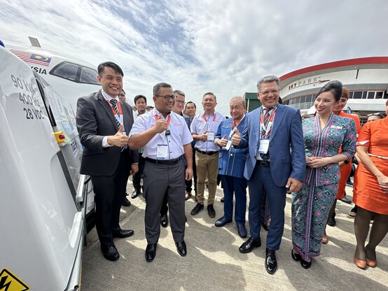A group of people in front of an electrical equipment.