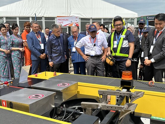 A group of people looking at an electrical equipment.