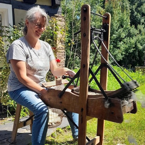 Eine Frau die Wolle kämmt